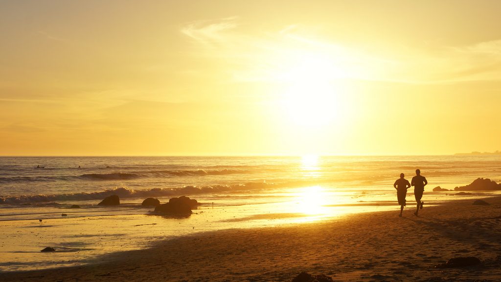 two men jogs on the beach