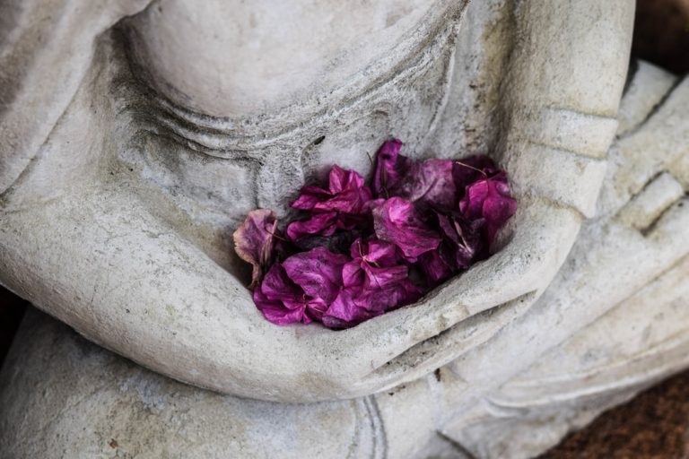 statue with cupping purple flowers